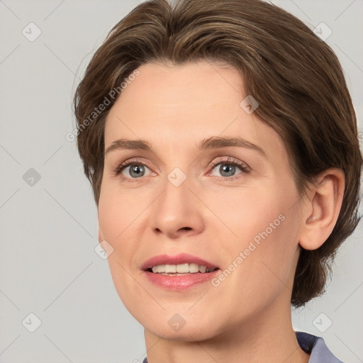 Joyful white young-adult female with medium  brown hair and grey eyes