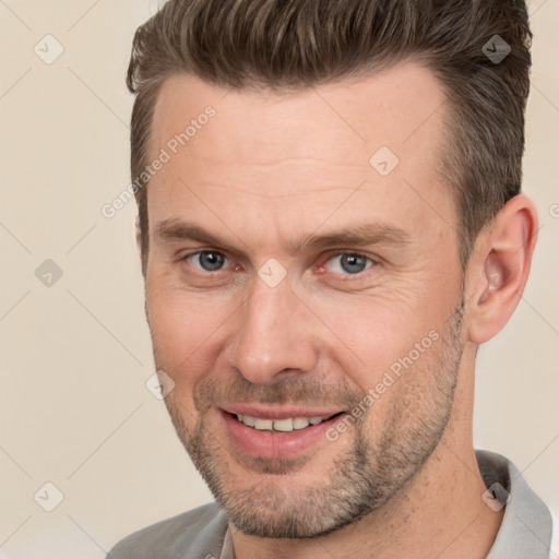 Joyful white adult male with short  brown hair and brown eyes