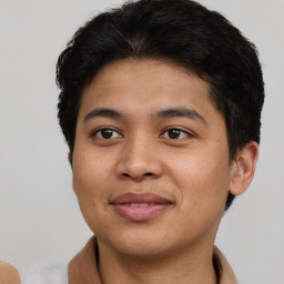 Joyful latino young-adult male with short  brown hair and brown eyes