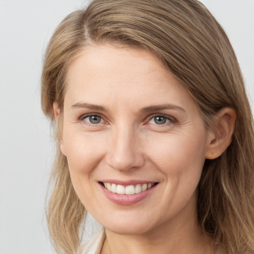 Joyful white young-adult female with long  brown hair and grey eyes