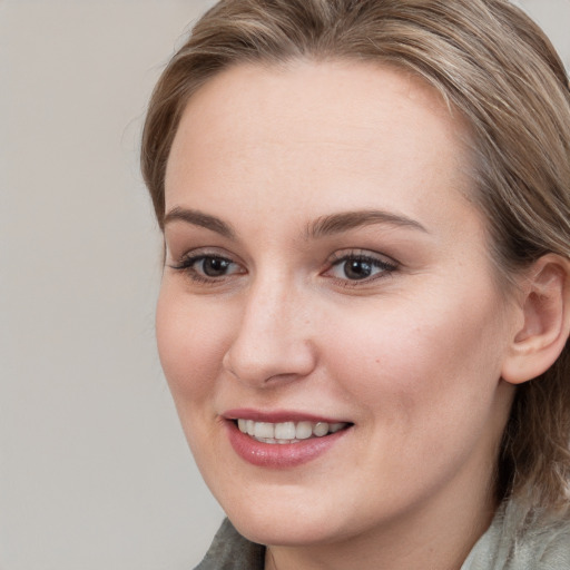 Joyful white young-adult female with medium  brown hair and blue eyes