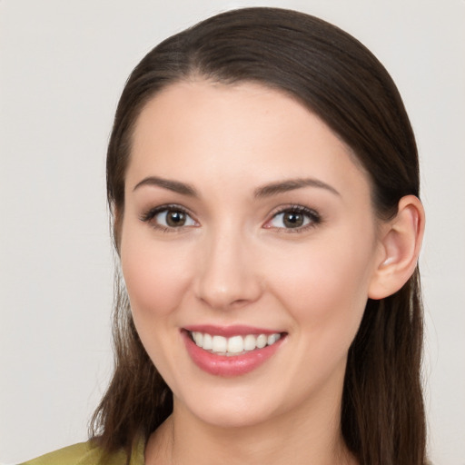 Joyful white young-adult female with long  brown hair and brown eyes