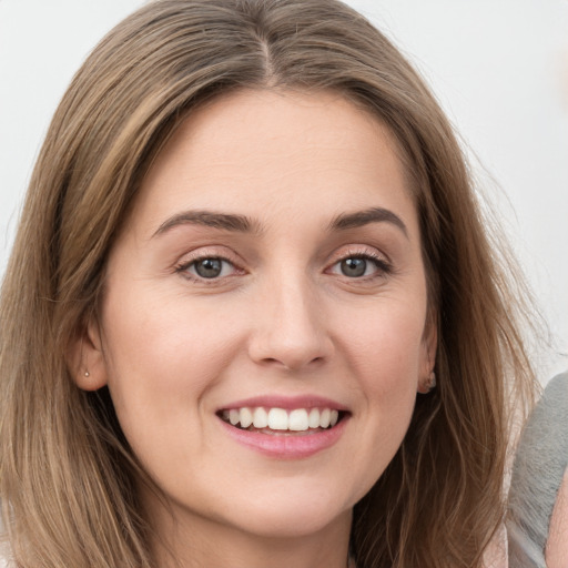 Joyful white young-adult female with long  brown hair and grey eyes