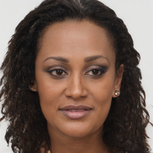 Joyful black young-adult female with long  brown hair and brown eyes