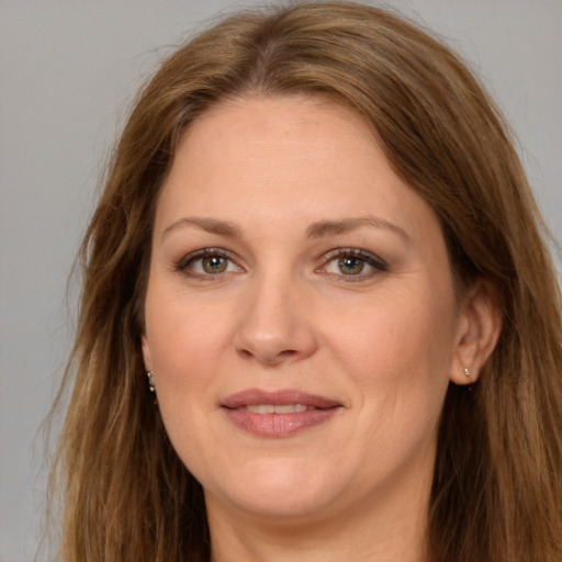 Joyful white adult female with long  brown hair and brown eyes