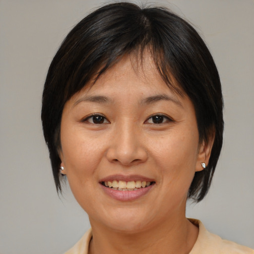 Joyful asian adult female with medium  brown hair and brown eyes