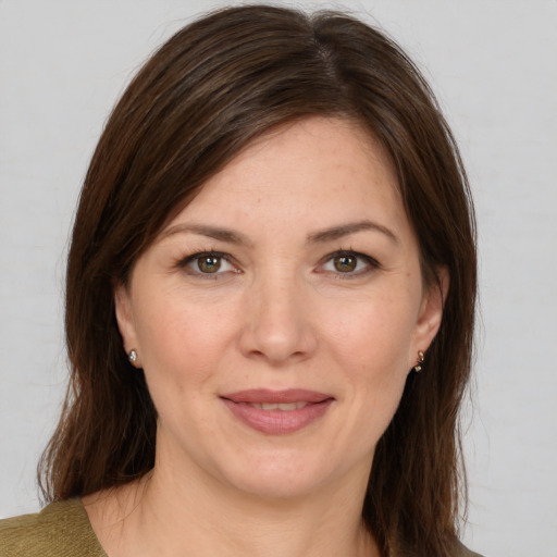 Joyful white adult female with long  brown hair and brown eyes