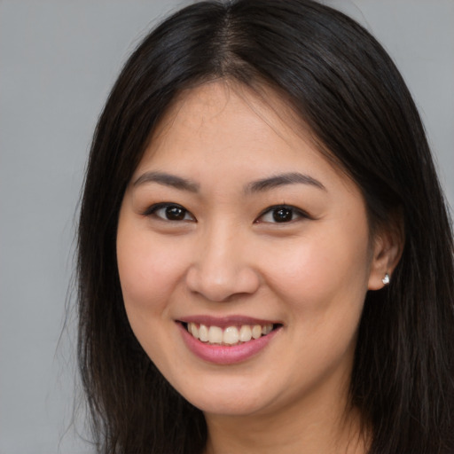 Joyful asian young-adult female with long  brown hair and brown eyes