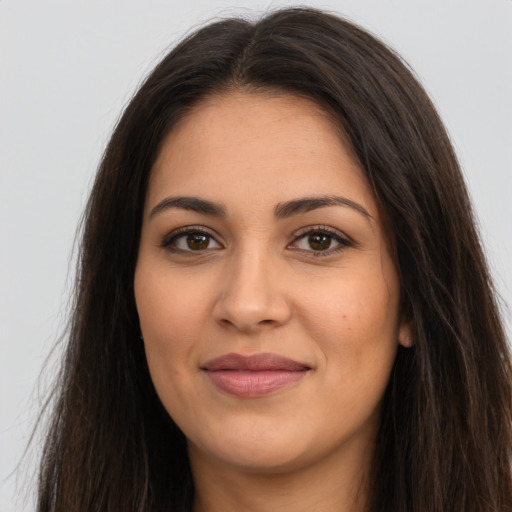 Joyful latino young-adult female with long  brown hair and brown eyes