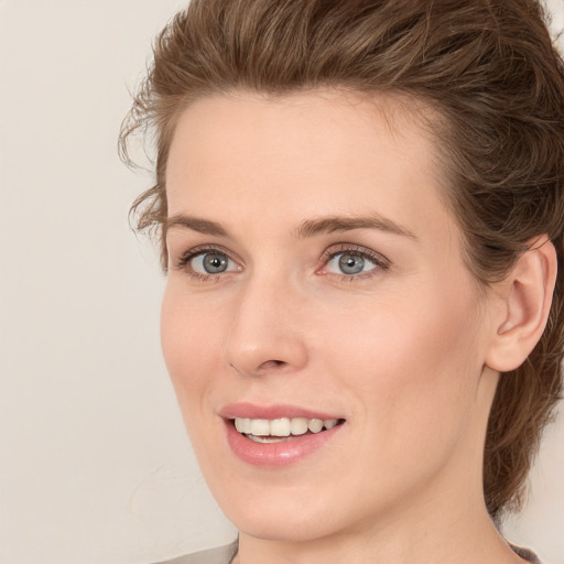 Joyful white young-adult female with medium  brown hair and blue eyes