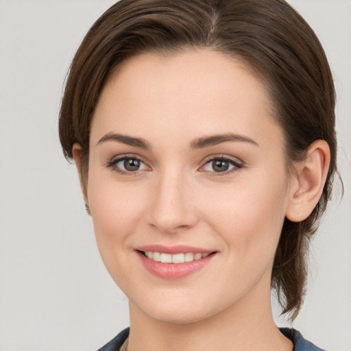 Joyful white young-adult female with medium  brown hair and grey eyes