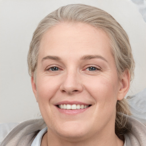 Joyful white adult female with medium  brown hair and blue eyes