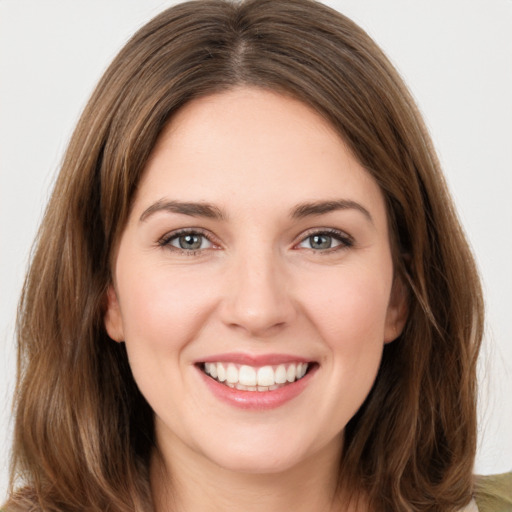 Joyful white young-adult female with long  brown hair and green eyes