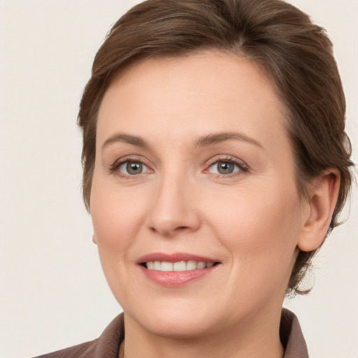 Joyful white young-adult female with medium  brown hair and grey eyes