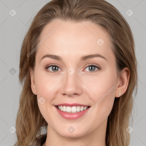 Joyful white young-adult female with long  brown hair and blue eyes