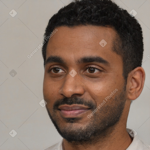 Joyful black young-adult male with short  black hair and brown eyes