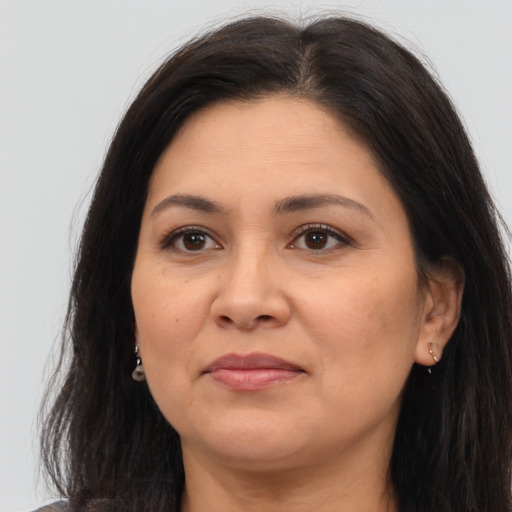 Joyful latino adult female with long  brown hair and brown eyes