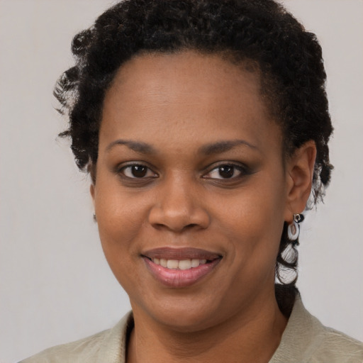 Joyful black young-adult female with short  brown hair and brown eyes