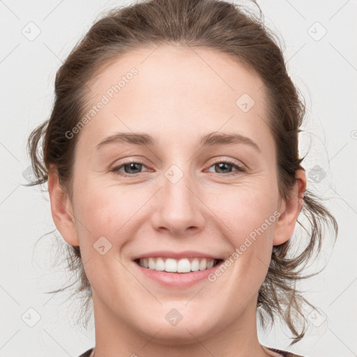 Joyful white young-adult female with medium  brown hair and grey eyes