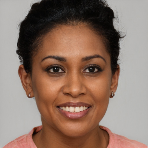 Joyful black young-adult female with short  brown hair and brown eyes