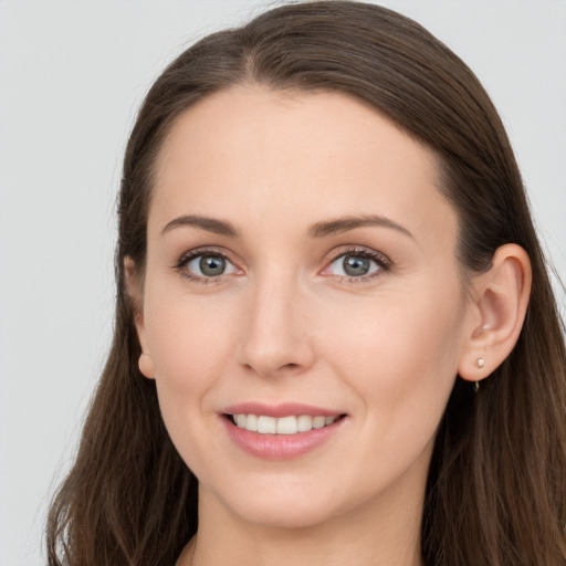 Joyful white young-adult female with long  brown hair and grey eyes