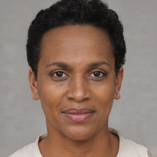 Joyful black adult female with short  black hair and brown eyes