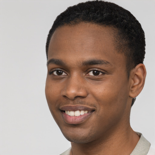 Joyful black young-adult male with short  black hair and brown eyes