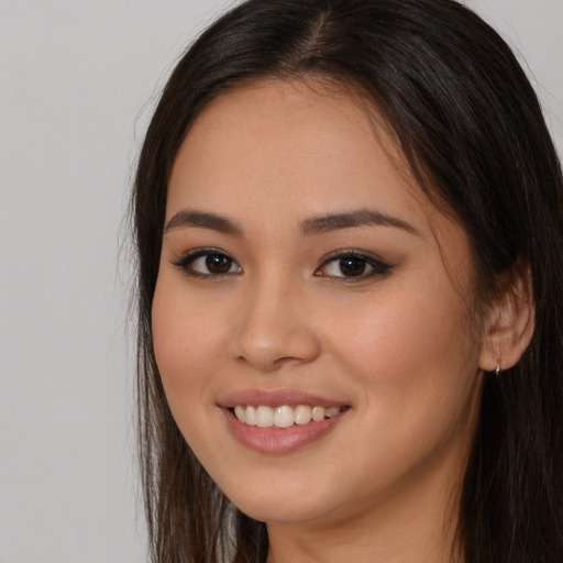 Joyful white young-adult female with long  brown hair and brown eyes