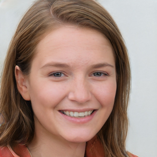 Joyful white young-adult female with long  brown hair and blue eyes