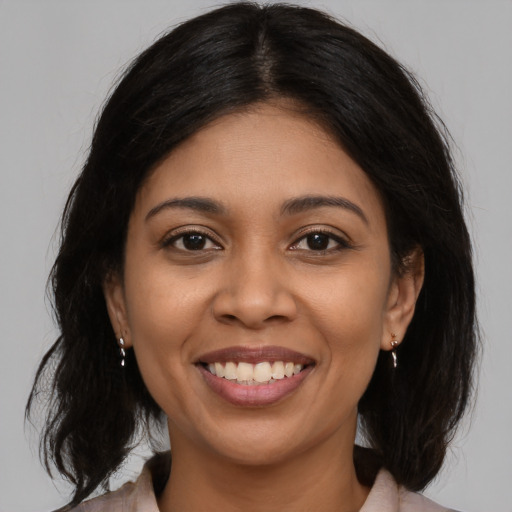 Joyful latino young-adult female with medium  brown hair and brown eyes