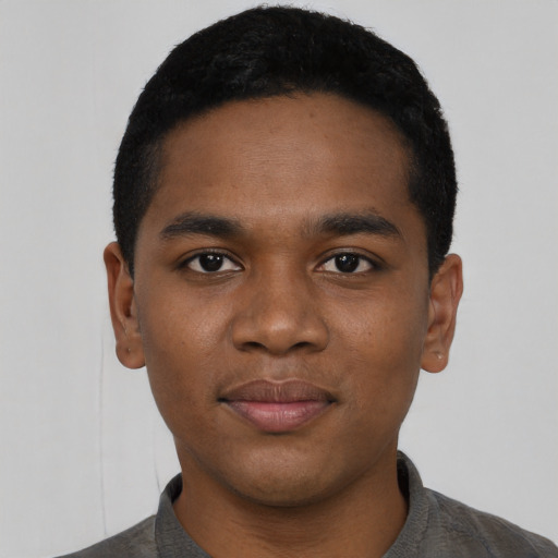 Joyful black young-adult male with short  black hair and brown eyes