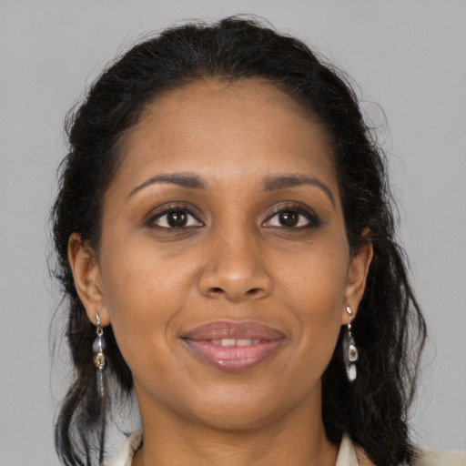 Joyful black adult female with long  brown hair and brown eyes