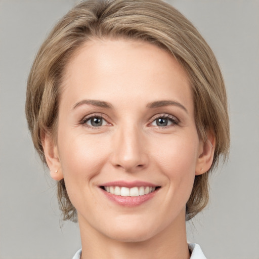 Joyful white young-adult female with medium  brown hair and grey eyes