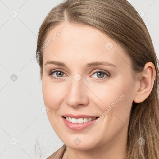 Joyful white young-adult female with long  brown hair and brown eyes