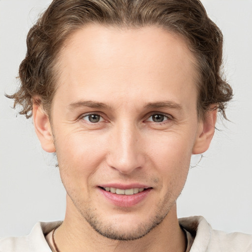 Joyful white adult male with short  brown hair and grey eyes