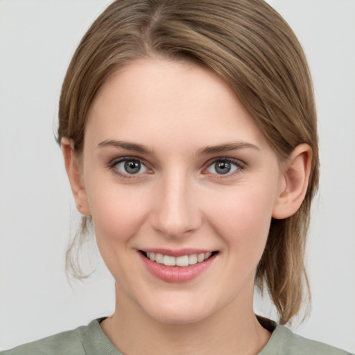 Joyful white young-adult female with medium  brown hair and grey eyes