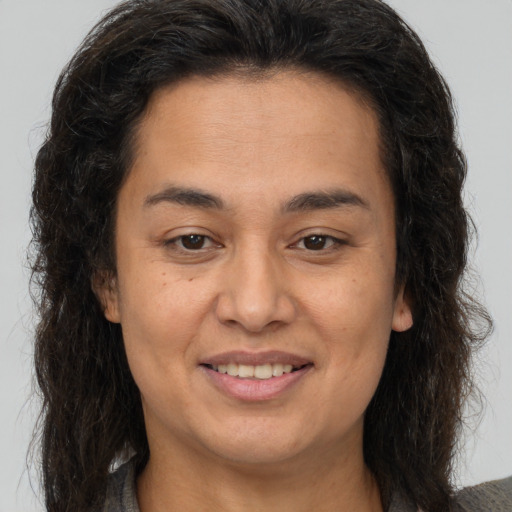 Joyful latino young-adult female with long  brown hair and brown eyes