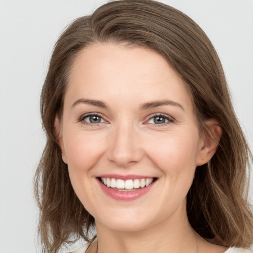 Joyful white young-adult female with medium  brown hair and grey eyes