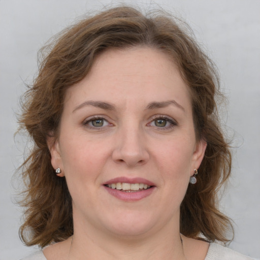 Joyful white adult female with medium  brown hair and grey eyes