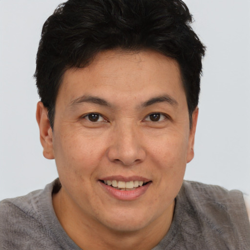 Joyful asian adult male with short  brown hair and brown eyes