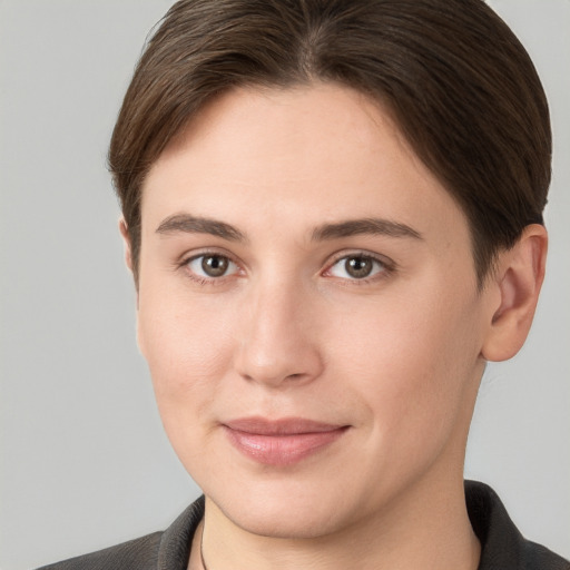 Joyful white young-adult female with short  brown hair and grey eyes