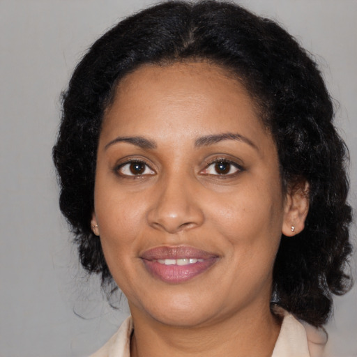 Joyful black adult female with medium  black hair and brown eyes