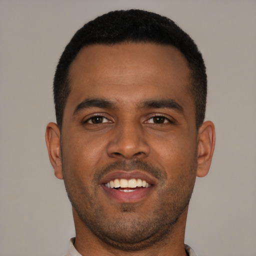 Joyful black young-adult male with short  black hair and brown eyes
