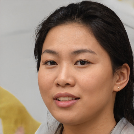 Joyful asian young-adult female with medium  brown hair and brown eyes