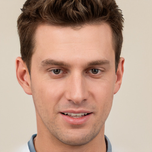 Joyful white young-adult male with short  brown hair and grey eyes