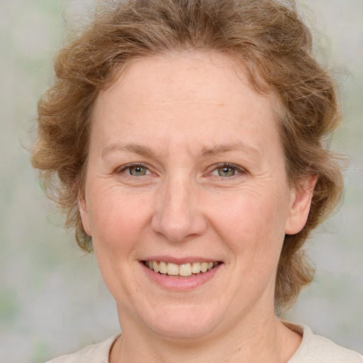 Joyful white adult female with medium  brown hair and blue eyes