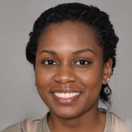 Joyful black young-adult female with medium  black hair and brown eyes