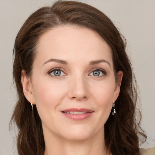 Joyful white young-adult female with long  brown hair and blue eyes