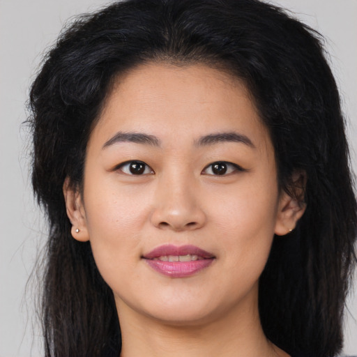 Joyful asian young-adult female with long  brown hair and brown eyes