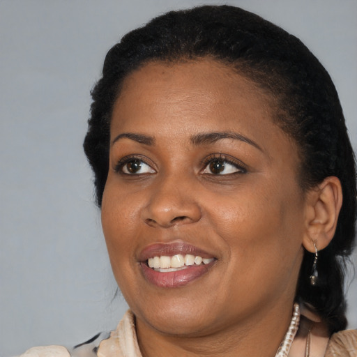 Joyful black adult female with short  black hair and brown eyes